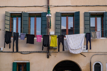 The laundry hangs on the wall of the house to dry.