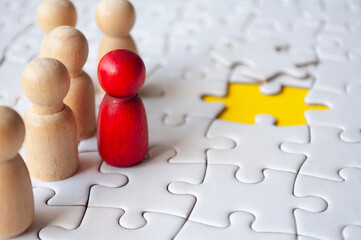 Wooden dolls on jigsaw with missing jigsaw puzzle. Hiring and employment concept.