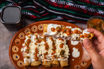 Woman's hand holding a golden taco to eat. Mexican food.