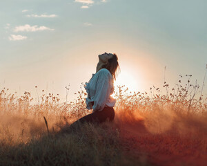 Fototapeta premium A woman in a field at dawn, feeling the warmth and freedom of the early morning light