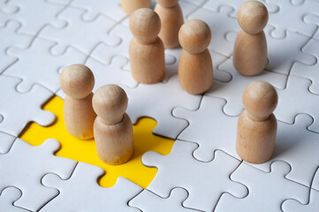 Two wooden dolls filled the missing jigsaw puzzle. Hiring and employment concept.