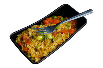 A slotted spoon over cooked noodles in a black bowl
