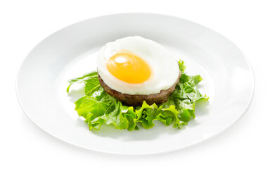 Fried chicken egg on a meat cutlet. Dish on a plate. Isolated.