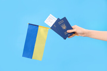 Woman with passports, ticket and flag of Ukraine on blue background