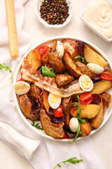 Plate of tasty potato salad with eggs, tomatoes and bacon on table, top view