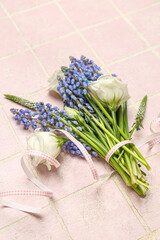Bouquet of beautiful Muscari and eustoma flowers on pink tiled background