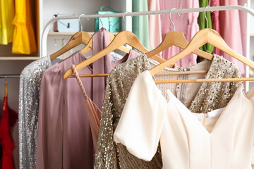 Rack with beautiful prom dresses in boutique, closeup