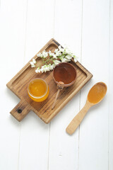 Composition with sweet honey and acacia flowers on light wooden background