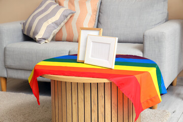 Blank frames with LGBT flag on table in living room