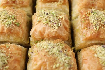 Delicious fresh baklava with chopped nuts as background, closeup. Eastern sweets