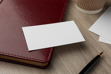 Blank business cards and notebook on wooden table, closeup. Mockup for design