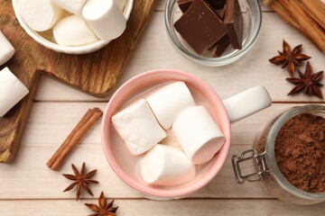 Tasty hot chocolate with marshmallows and ingredients on white wooden table, flat lay
