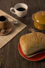 Whole wheat bread and hot drinks on wooden table.