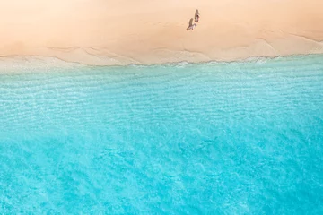 Papier Peint photo Turquoise Aerial view of amazing beach with couple walking in sunset light close to turquoise sea. Top view of summer beach landscape, romantic love couple vacation, romantic holiday. Freedom leisure activity 
