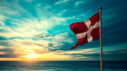 Danish flag waving at sunset by the ocean.
 - obrazy, fototapety, plakaty