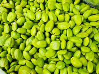 pile of green bitter bean seeds. fresh green bitter bean seeds full frame. Parkia speciosa is a tropical annual tree from the legume family Fabaceae, a sub-tribe of petai-petaian Mimosoidae.