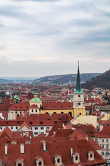 Fototapeta na wymiar Panoramic view of the medieval city Prague during winter with a church and mountains in the background