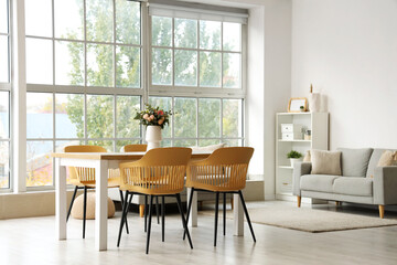 Interior of light room with flower vase on dining table