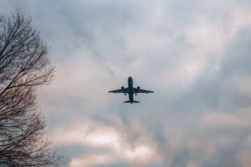 Passenger plane landing at the airport, under a blue sky with white clouds. San Donato Milanese,...