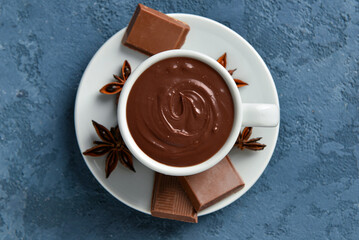 Cup with tasty melted chocolate on blue background