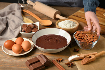 Woman preparing tasty melted chocolate at table