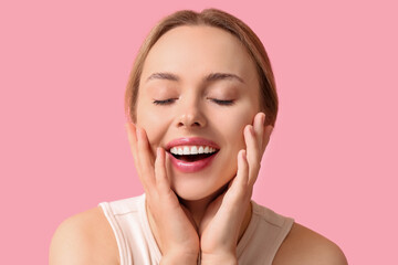 Beautiful young woman on pink background