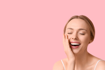 Beautiful young woman on pink background