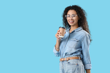 Young African-American woman with coffee cup on blue background