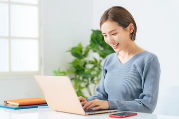 笑顔でノートパソコンを使う女性