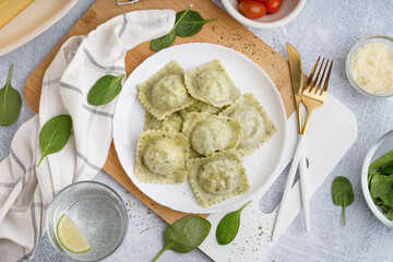 Plate of tasty ravioli and glass with water on white background