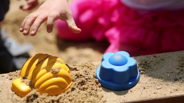 Cute curly children made sand-pie: a shell and flower.