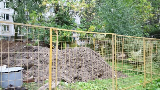 Yellow grid enclose place of repair of canalization pipes 