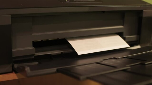 Office desktop laser printer printing single A4 letter page. The process of printing on paper using a printer.
