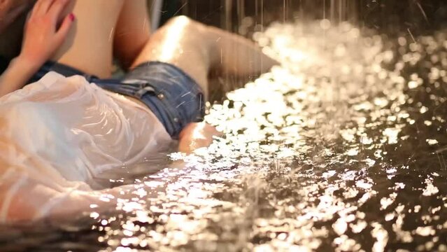 Water dripping on body of the girl which lies in the water