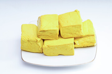 yellow tofu boxes stacked and isolated on white background. Foods high in vegetable protein are good for vegetarians.