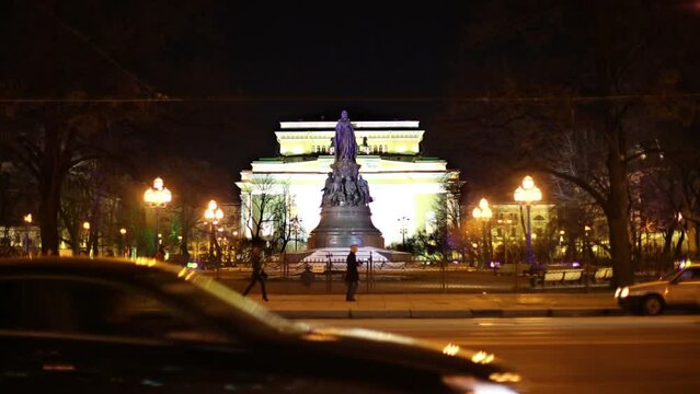 People and car traffic against Ostrovsky Square at night.