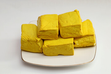 yellow tofu boxes stacked and isolated on white background. Foods high in vegetable protein are good for vegetarians.