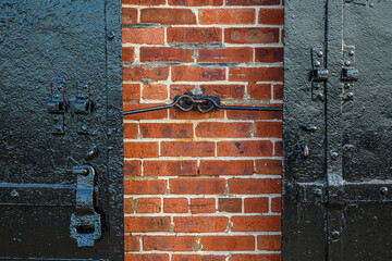 Detail of Black metal door of old building red bricks facade in Red hook, Brooklyn, New York, USA