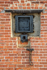 Fototapeta na wymiar Detail of lock system of Black metal door in old building red bricks facade in Red hook, Brooklyn, New York, USA