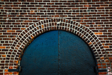 Detail of black door arch on brickwall in Red Hook, Brooklyn, New York