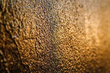 Black paint on metal hit by sunset reflection for background