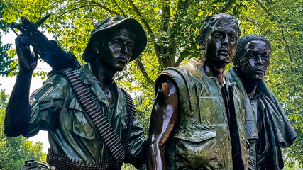 Photograph of the monument and bronze statue of the three soldiers, Vietnam Veterans Memorial on the National Mall in Washington DC, USA. - Powered by Adobe