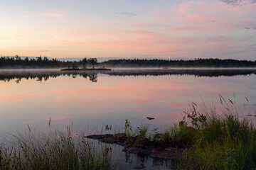Pastel colors of the night sky reflected on the still surface of a small lake