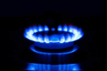 Gas flame, burning gas stove burner on a black background. Copy space.
