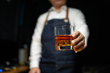 Barman pouring whiskey whiskey glass..