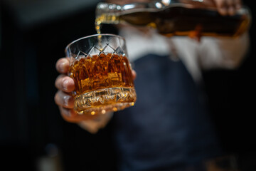 Barman pouring whiskey whiskey glass..