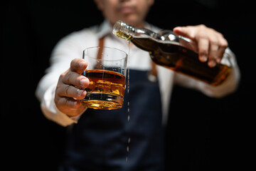 Barman pouring whiskey whiskey glass..