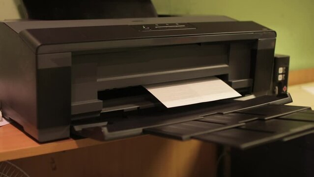 Laser Print machine printing documents in office. The process of printing on paper using a printer.