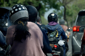 road traffic in Indonesia, motorbike and car riders crowd the roads. very busy traffic. fossil fuel...
