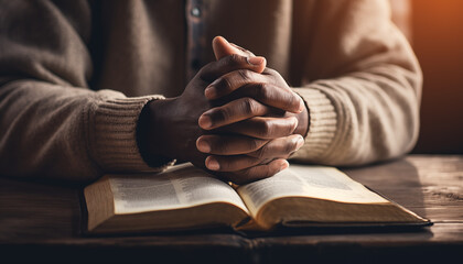 hands together in prayer to God along with open bible